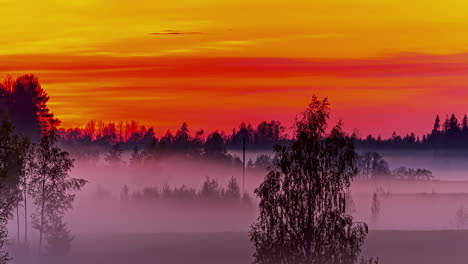 Cielo-Rojo-Del-Atardecer-Y-Niebla-Rodante-Sobre-El-Paisaje-Rural,-Lapso-De-Tiempo-De-Fusión