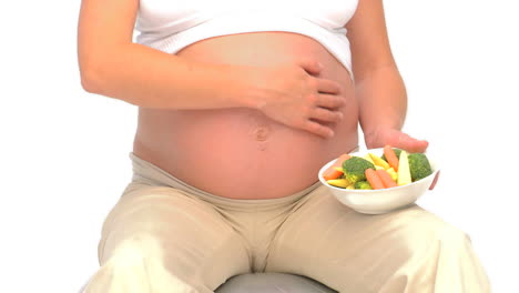 pregnant woman holding vegetables