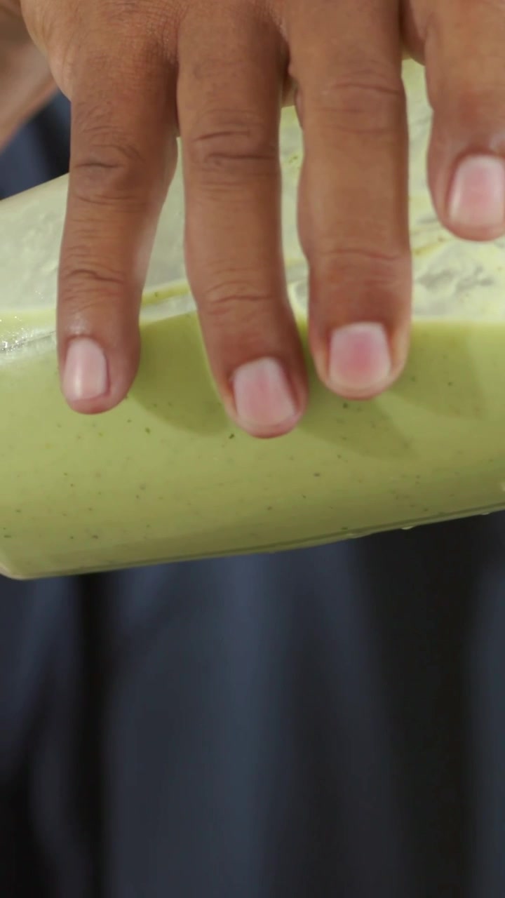 Vertical video: Reaching right hand pressing, shifting to center mint mug at home, with navy fabric