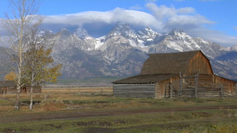 Un-Antiguo-Granero-Se-Encuentra-Con-Las-Montañas-Grand-Teton-Al-Fondo