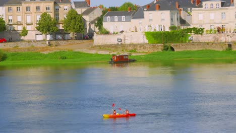 couple kayaking on a calm river in a picturesque french town