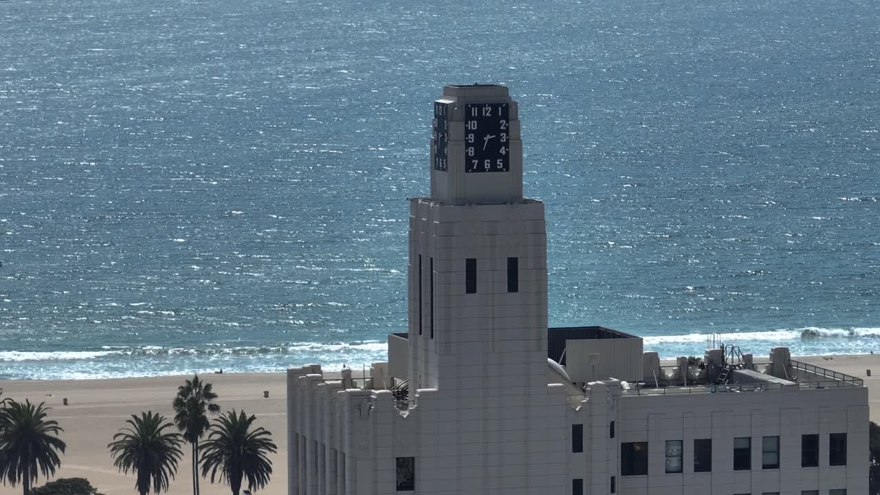 Telefoto droneoptagelse af den historiske klokketårnsbygning og Santa Monica Strand.
