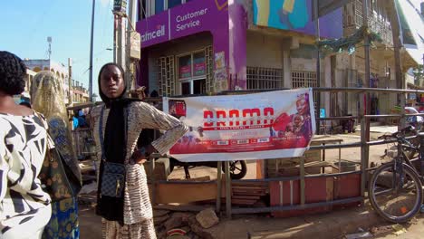 pov walk through crowded streets of serekunda market, featuring local vendors and colorful displays as cars cross in front of path
