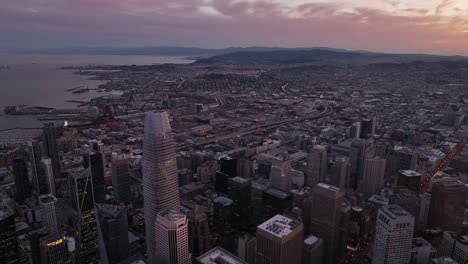 aerial of san francisco downtown skyline with mountains and bright sunset sky in the distance