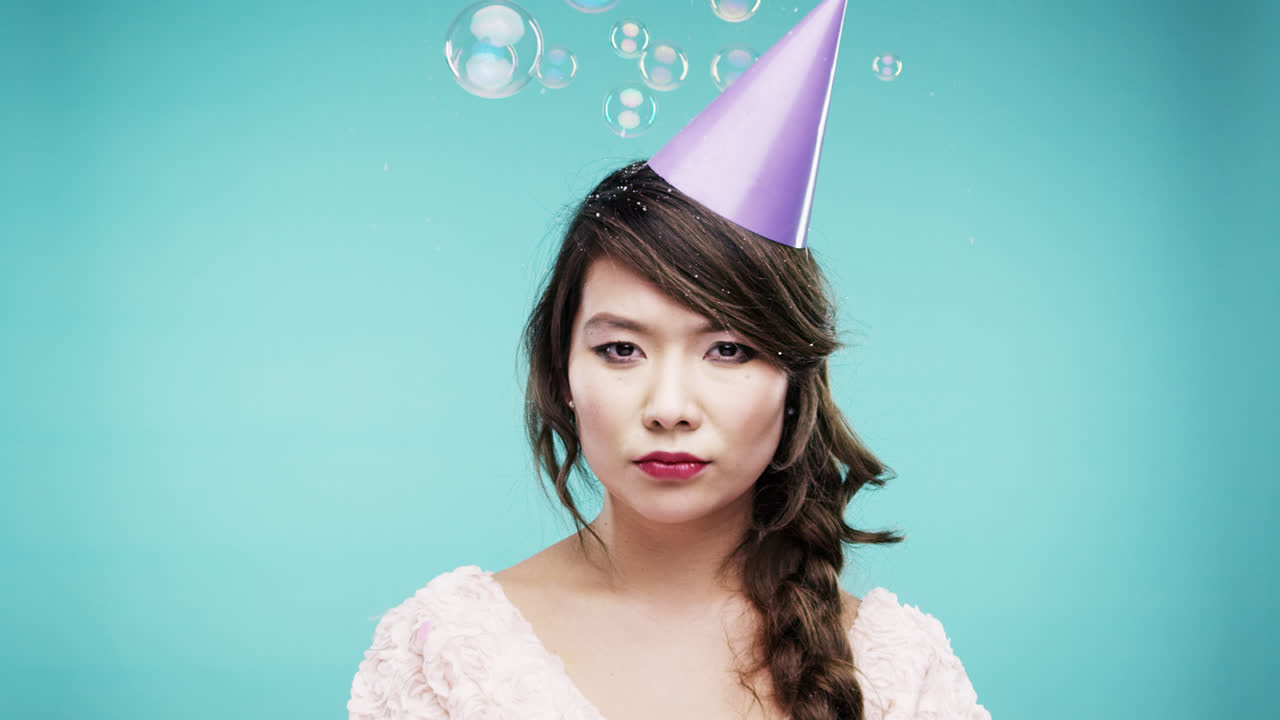 미친 얼굴 아시아 여성이 거품 샤워에서 춤을 추고 슬로우 모션 사진 부스 파란색 배경