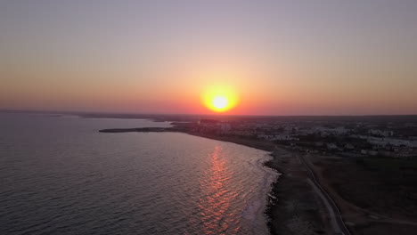 Toma-Aérea-De-Una-Puesta-De-Sol-Sin-Nubes-De-La-Costa-Del-Mar-En-Un-Centro-Vacacional