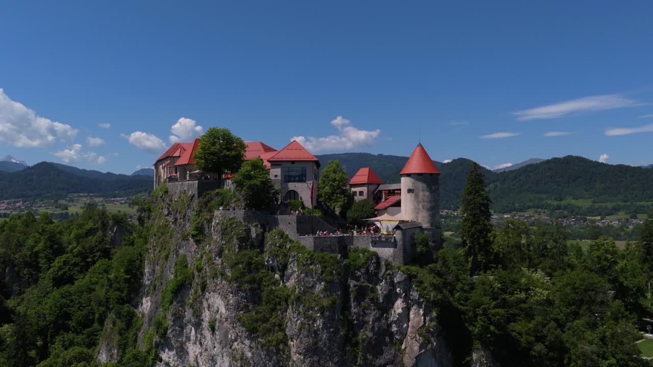 Ripresa con drone del Castello di Bled arroccato in modo spettacolare su una scogliera sopra il lago turchese di Bled