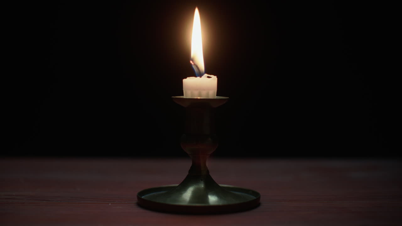 A candle burs out in the dark room