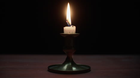 a candle burs out in the dark room