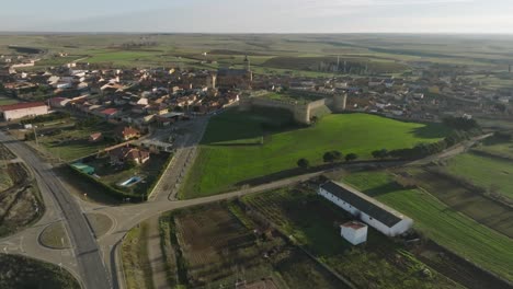 Castie-Medieval-Panorámica-Aérea-En-Los-Campos-Rurales-De-La-Ciudad-Española-Grajal-De-Campos-Drone-Estableciendo-Una-Toma-Panorámica,-Horizonte-De-Luz-Diurna