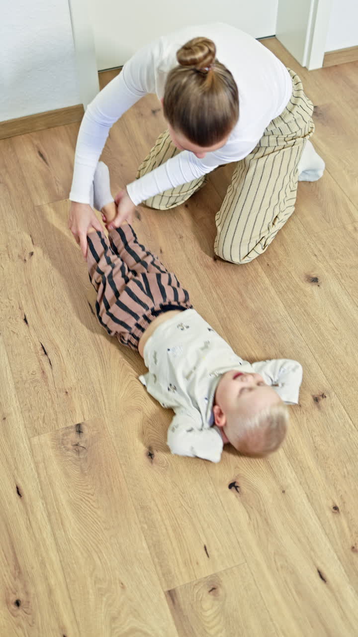 Madre amorevole trascorre del tempo con il suo figlioletto. Madre in congedo di maternità gioca con suo figlio. Famiglia felice a casa durante giochi divertenti.