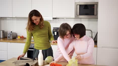 down syndrome girls with mother on kitchen after shopping, slow motion