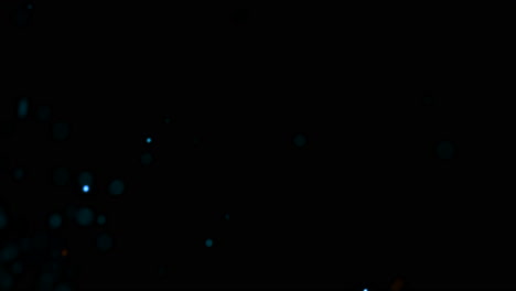 mover y volar partículas azules y naranjas en el fondo cinematográfico