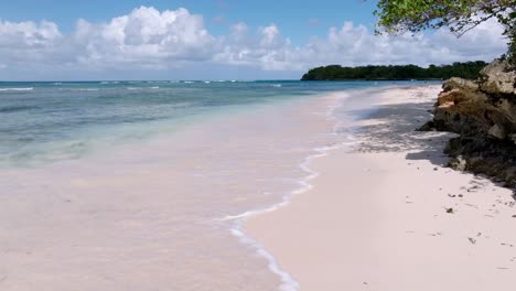 waves of caribbean sea reaching sandy beach of playita beach