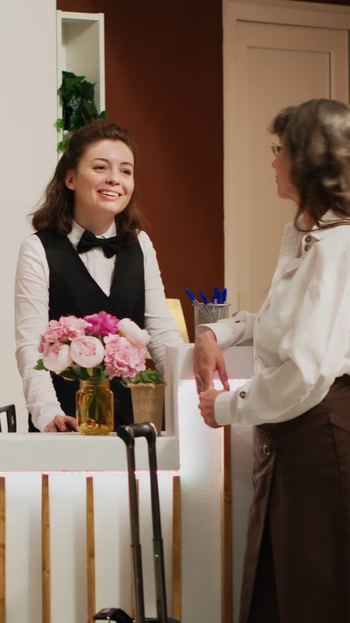 Video verticale: cliente donna effettua il check-in in un hotel di lusso
