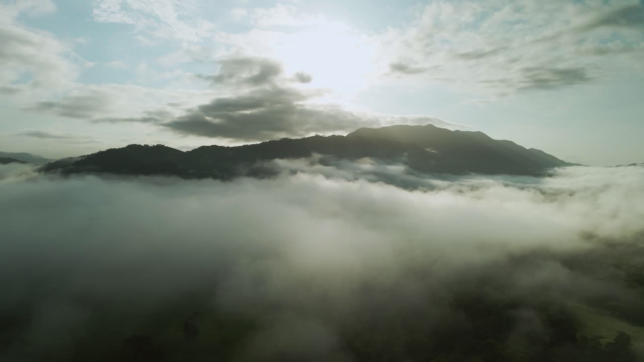 Flight over the mist in the sunset time, Costa Rica. tilt up drone shot