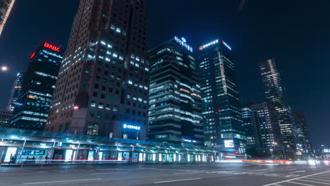 yeouido transfer center and nigth traffic time lapse in seoul downtown, high-rise towering skyscrapers in background - wide low angle view zoom out