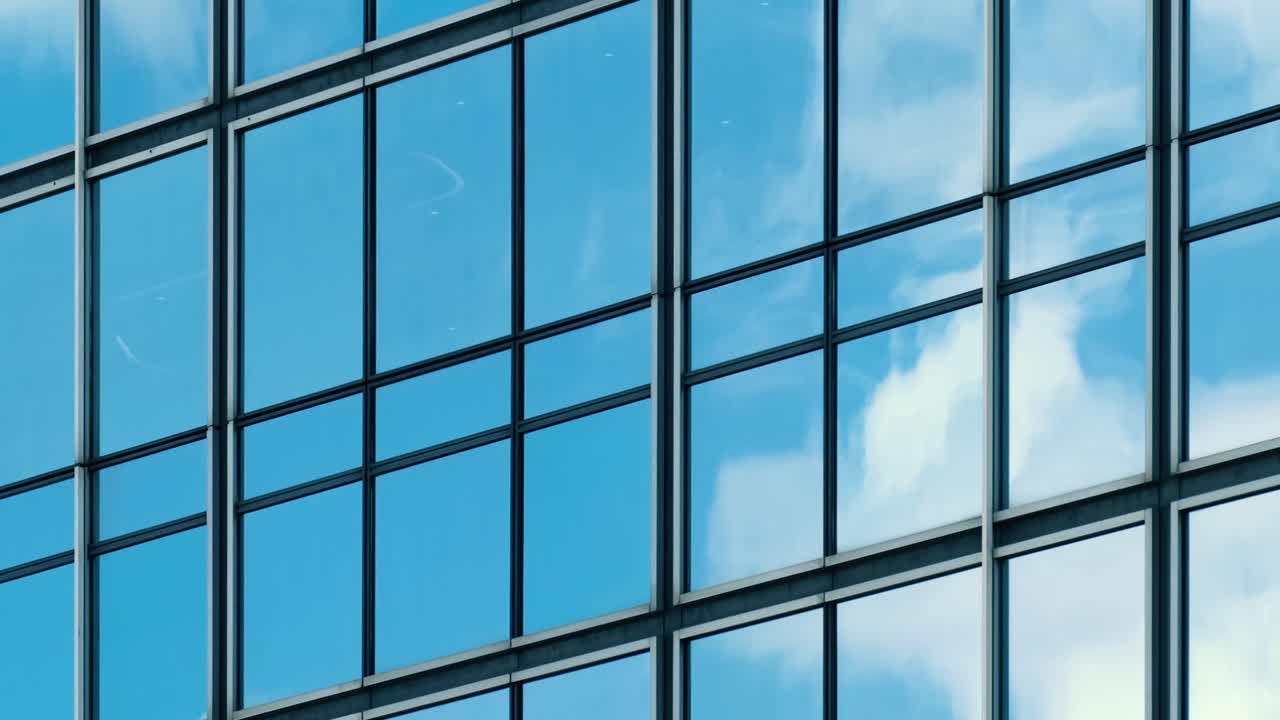 lapso de tiempo de cielo azul y nubes reflejadas en la pared de vidrio modular estructural