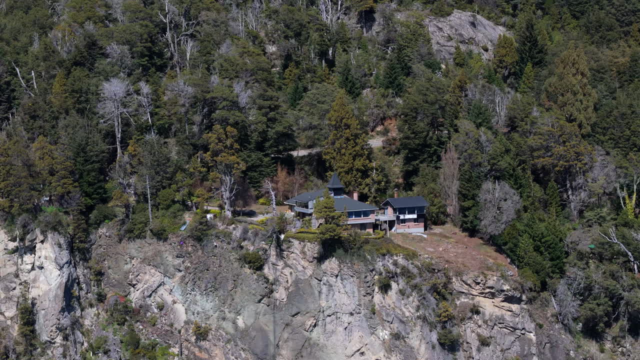 casa situada en un acantilado de montaña, rodeada de bosque