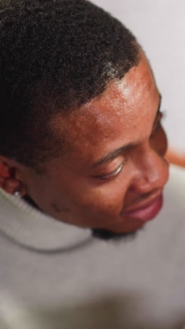 pretty young white woman talks to nodding african-american man groupmate spending time together in living room close view slow motion
