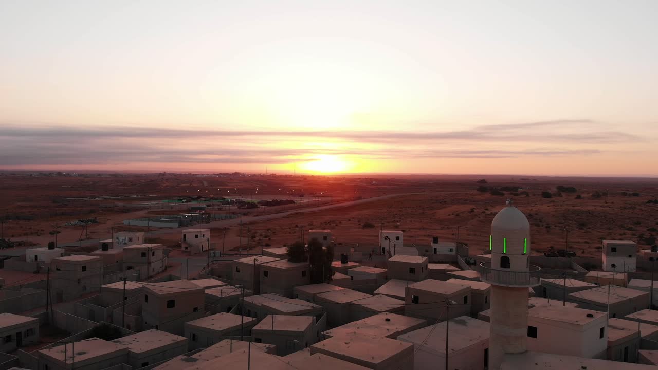 aerial shot of sunrise in an old empty city in the desert in palestine near Gaza camera pass next to a mosque.