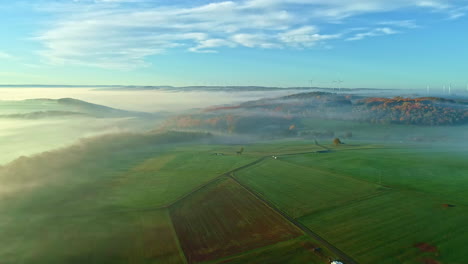 a magical landscape with green meadows, hills and windmills in the background