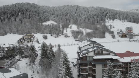 an aerial view of a bustling ski resort, showcasing ski runs and snow-covered buildings