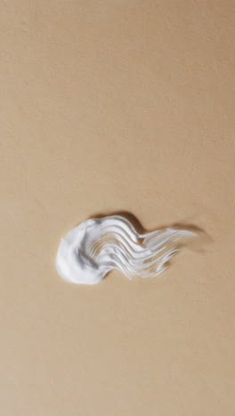 vertical video of cream smudges with copy space on yellow background