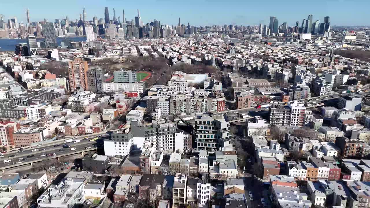 Horizontal drone orbit shot over Withers Street in Brooklyn, showcasing the city's vibrant streets, historic architecture, and dynamic urban landscape with smooth circular motion.