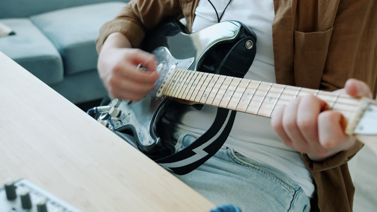 hombre tocando la guitarra eléctrica en casa