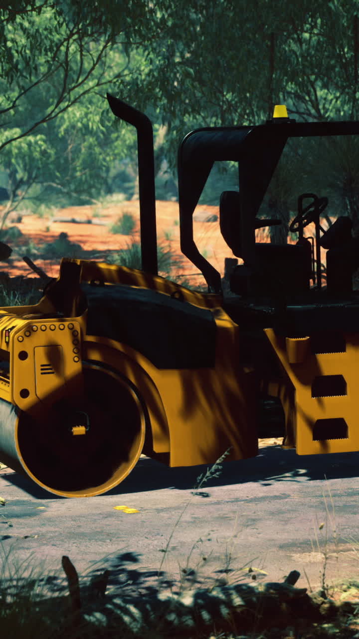 Heavy machinery operates under a vibrant canopy in a sunlit clearing