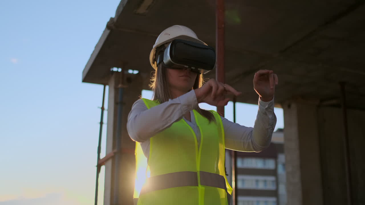 mujer ingeniera experta constructora en vr gafas y casco comprueba el progreso de la construcción de rascacielos moviendo sus manos al atardecer visualizando el plan del edificio