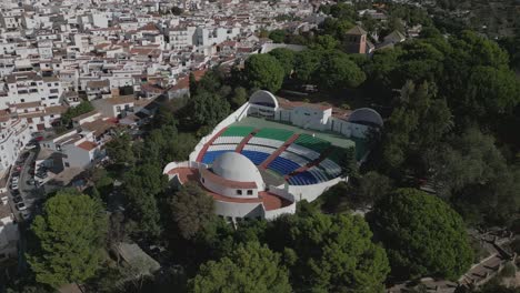 outdoor amphitheater in mijas, surrounded by white spanish buildings and greenery, aerial view