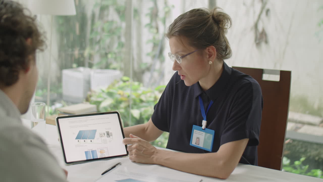 Female Engineer Explaining Project on Tablet to Business Partner