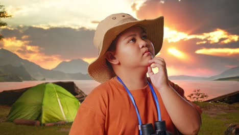thoughtful boy camping at sunset