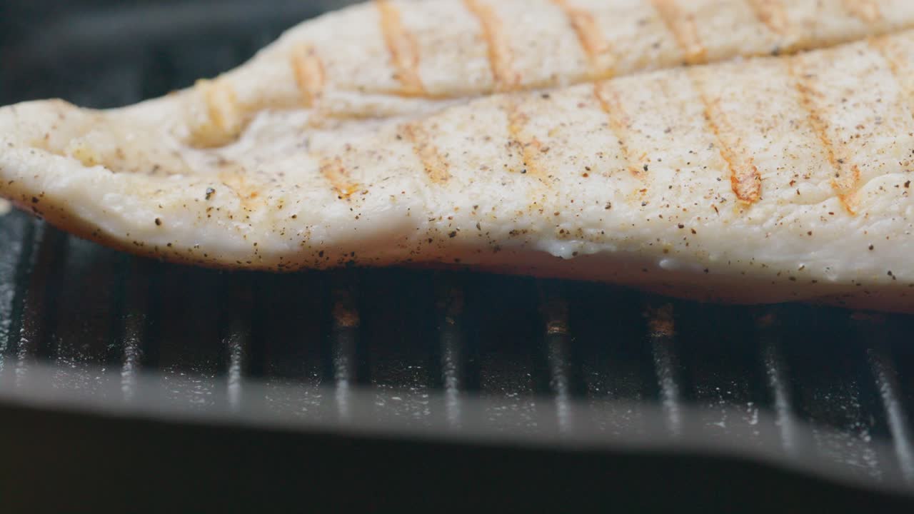 Flipping Juicy Chicken Fillet on Hot Grill during Cooking