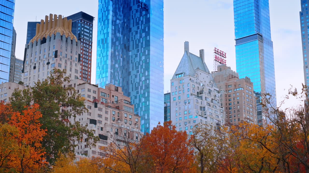Nova Iorque, EUA, 22 de Outubro de 2025: Arquitetura notável de Manhattan vista do Central Park, Nova Iorque, EUA. Vista de baixo ângulo do topo das árvores coloridas de vermelho, laranja e amarelo no outono