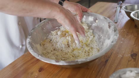 caucasian female chef mixing dough in a bowl