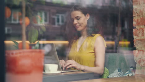 woman working on laptop in a cafe