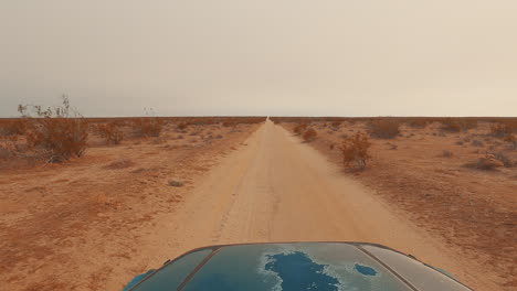 driving along an off-road trail in the barren and endless mojave desert landscape