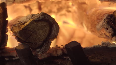 wooden logs burning and glowing in fireplace, close up time lapse