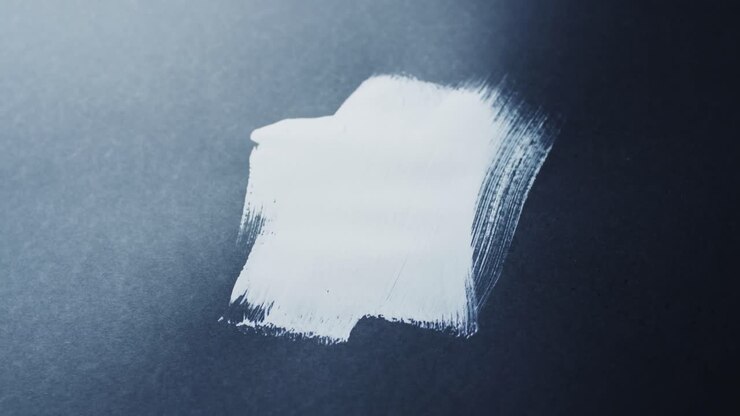 Close up of white paint shapes on black background with copy space, slow motion