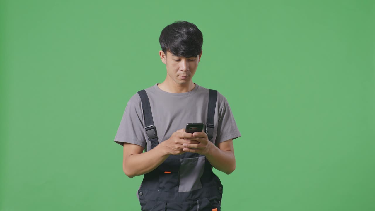 스마트폰을 보고 있는 오버을 입은 남자