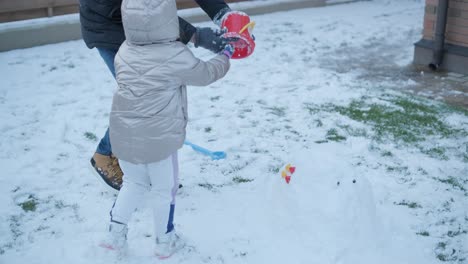 grandfather and granddaughter having fun in the snow