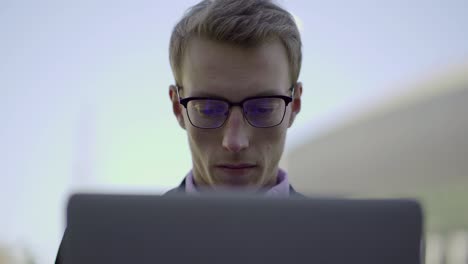 hombre de negocios enfocado trabajando con computadora portátil al aire libre