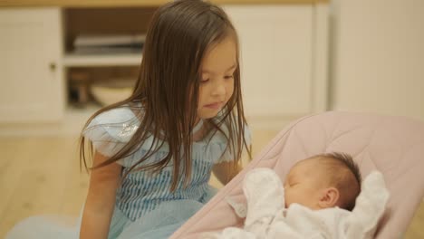 una niña jugando alegremente con su hermana pequeña en casa. el momento captura el vínculo entre hermanos y el amor familiar en un ambiente interior acogedor