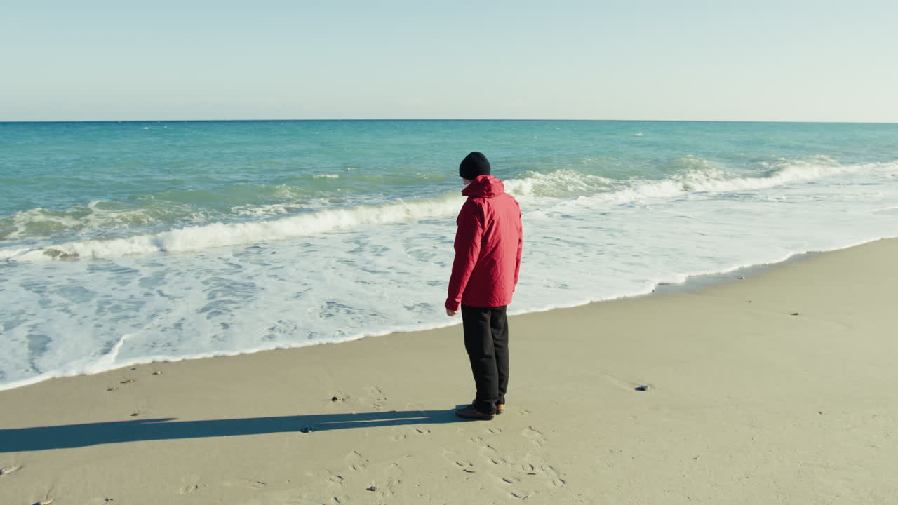 Elderly Man Relaxes by the Sea on a Sunny Winter Day