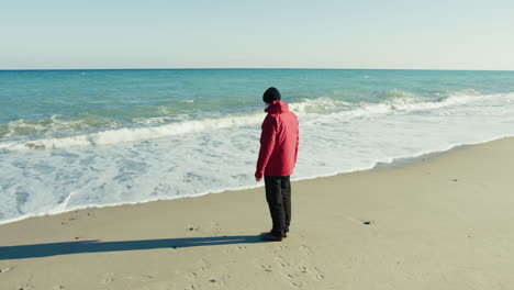 elderly man relaxes by the sea on a sunny winter day