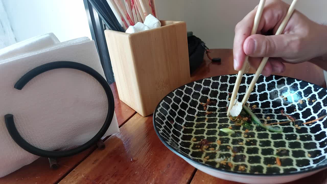 Finishing the last morsel of food from a plate, candid mundane moment of daily life