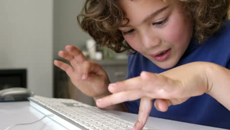 niño escribiendo en un teclado blanco